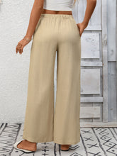 Beige wide leg drawstring high waist pants with elastic waistband and subtle textured fabric for comfortable wear