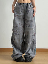 Gray drawstring plaid wide leg pants with black drawstrings and a cosmic-themed print for stylish casual wear