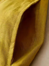 Wide-leg pants in golden-yellow silk-like fabric with subtle woven texture and neatly stitched seam