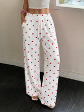 White wide-leg pants with red heart print and elastic drawstring waist featuring a heart print drawstring design