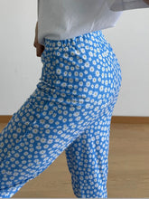 Blue high-waisted floral print flare leg pants featuring a white daisy print perfect for casual wear