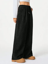 Black corduroy wide-leg pants with elastic waistband and drawstring suitable for machine wash care instructions