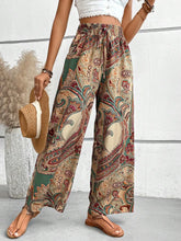 Printed wide leg pants featuring flared wide leg design with vibrant paisley pattern in earthy green red and beige tones