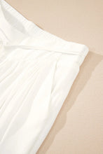 White flowy wide leg pants with pleated fabric and elastic drawstring waistband for comfortable wear