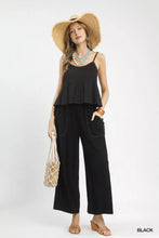 Black ruffled sleeveless top with scalloped edge and thin straps paired with linen frayed side pocket wide leg pants