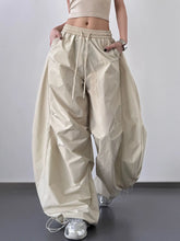 Beige oversized baggy wide leg drawstring pants made of glossy lightweight fabric with an elastic waistband