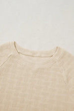 Cream-colored textured crew neck cap sleeve slim top with leaf pattern
