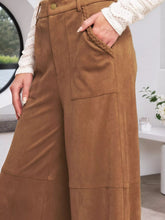 High-waisted brown suede wide-leg pants with braided pocket detail suitable for versatile styling and care instructions