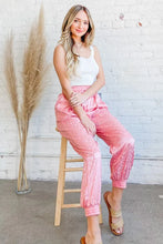 Pink leopard print satin joggers with elastic cuffs designed for comfort and machine wash cold care instructions