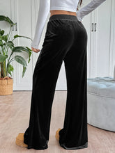 Black velvet wide-leg drawstring pants with a comfortable elastic waistband and easy care instructions