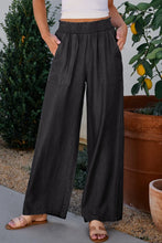 Black wide-leg trousers with smocked high waist elastic waistband and two front patch pockets for comfortable wear