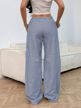 Blue and white vertically striped drawstring striped wide leg pants with elastic waistband and wide leg fit