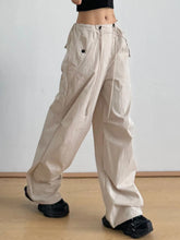 Beige relaxed wide-leg drawstring pants with cargo style and multiple pockets for casual comfort and utility