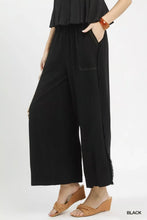 Black linen wide leg pants with frayed hem and subtle stitching details featuring side pockets
