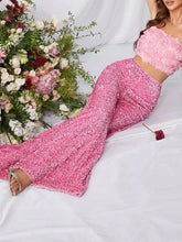 A shimmering pink sequin embellished wide leg pants set with a cropped top featuring rose embellishments