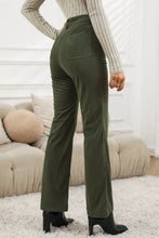 Olive green corduroy pants with high waist square pockets and a flare leg design in corduroy fabric
