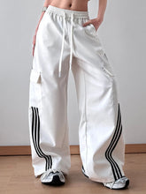 White cargo pants with black striped wide leg detailing and drawstring waistband for a comfortable wide leg cargo fit