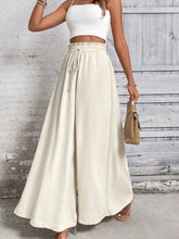 Cream-colored frill wide leg pants with high-waisted elastic drawstring waistband and wide leg silhouette
