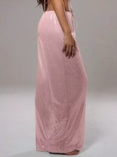 A flowing light pink sequin wide leg pants with high waist and thin side ties in a maxi skirt style