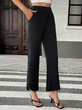Black pearl-embellished cropped wide-leg pants featuring high-waisted fit and flared cuffs with pearls