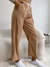 Beige wide leg drawstring casual pants featuring high-waisted jogger style with drawstring waistband and side seam stitching