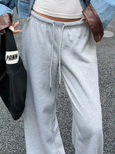 Wide leg drawstring sweatpants in gray heathered fabric with brown leather pocket accents and a drawstring waistband