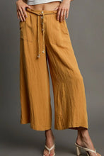 Mustard-yellow Umgee wide-leg pants with rope drawstring waist and front pockets featuring easy care instructions