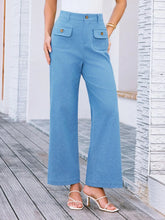 Light blue high waist wide leg pants with front pockets and gold tone buttons in a stylish wide leg design
