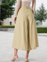 Beige high-waisted pleated wide-leg cropped pants in smooth structured fabric with cropped length and high waist design