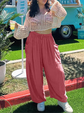 A woman wearing cream crochet crop top and pink full size wide leg pants with pockets in plus size wide leg fit