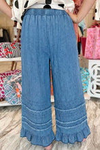 Blue chambray pants with wide leg silhouette featuring ruffled hem and gathered detailing for a stylish look