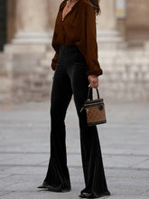 Brown monogram canvas mini handbag with black leather trim and handles complementing high waist velvet flare pants
