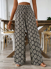 Black and beige high-waisted printed wide leg pants with geometric pattern and drawstring waist for casual wear