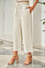 Cream-colored linen drawstring paperbag waist wide leg pants with elastic waistband for comfortable wear