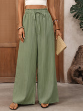 Mint green wide leg drawstring waist pants with pleated fabric and elastic waistband for comfortable wear