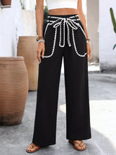 Black wide-leg pants with white crochet trim and a matching tie waist crochet trim tie belt for stylish wear