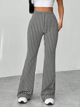 Black and white houndstooth high waisted flare pants featuring a classic pattern and flared leg silhouette