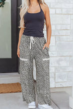 Animal print wide leg terry knit pants featuring leopard print fabric with white drawstring and side pockets