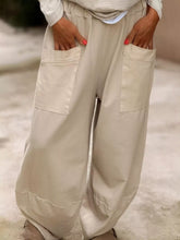 Beige plus size relaxed fit wide-leg pants with large front pockets and a loose casual style