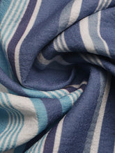 A soft woven scarf with a blue and white stripe pattern complementing wide-leg pants for a perfect fit