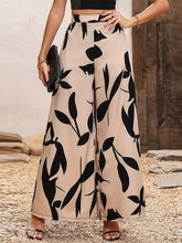 Beige printed wide leg pants featuring a bold black leaf pattern in a comfortable wide leg design