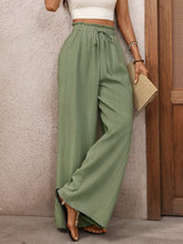 Mint green wide leg drawstring waist pants featuring a scalloped hem for a stylish and comfortable fit
