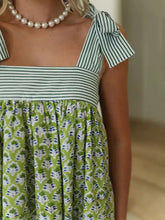 Green and white striped floral summer dress with ruffled details and pearl necklace