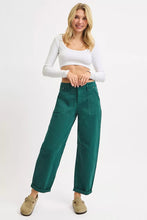 Emerald green high rise ankle cuffed wide-leg trousers with rolled cuffs and front pockets by risen