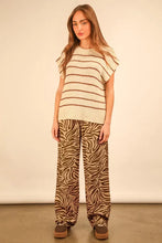 Cream-colored knit top with brown stripes and fluttery sleeves paired with very j animal print wide leg pants
