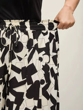 Plus size black and white abstract print wide-leg pants with geometric pattern and drawstring waistband