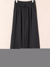 Black wide-leg sweatpants with tied elastic high waist and drawstring tie featuring pleated detail for comfort