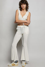 White flared pants with a drawstring waistband and subtle textured ribbed knit detail for comfortable wear