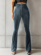 High-waisted ribbed velvet flare pants in dark teal with luxurious vertical ribbed texture for elegant wear