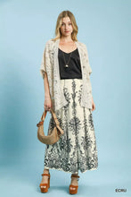 Beige crochet open-front cardigan with delicate lace detailing paired with umgee border print wide leg pants